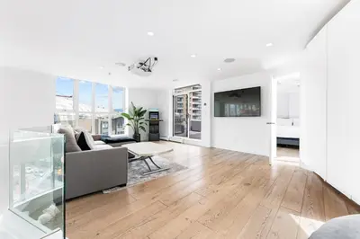 a white living room with a couch and a table at The Vancouver Penthouse, 2-Level, Patios, Hot Tub in Vancouver