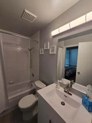 a bathroom with a sink and a toilet and a tub at Cozy Condo in the heart of the city in Vancouver