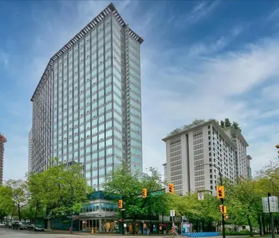 a tall building with many windows on a city street at Cozy Condo in the heart of the city in Vancouver