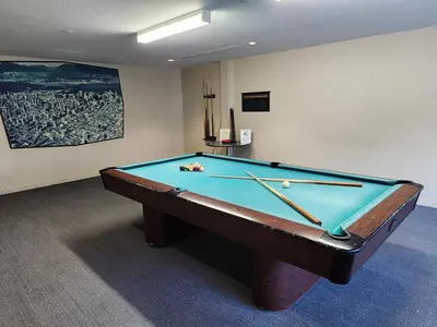 a pool table in a room with ahibition at Cozy Condo in the heart of the city in Vancouver