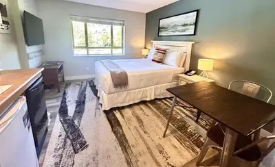 a bedroom with a bed and a table in it at Cascade Lodge Studio-steps from village in Whistler