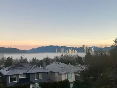 a view of a foggy city with buildings and houses at Lovely suite in Burnaby