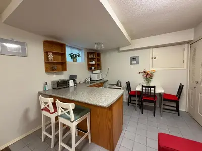 a kitchen with a counter and a table and chairs at Lovely suite in Burnaby