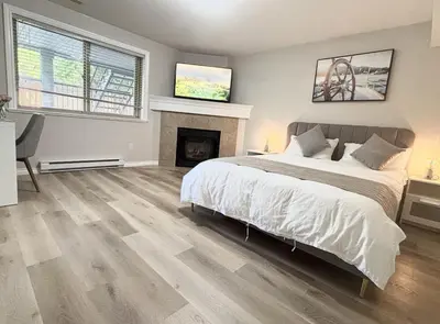 a bedroom with a large bed and a fireplace at Bella Sweet Suite -Cozy 2B suite Morgan Creek in Surrey