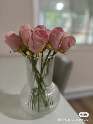 a vase filled with pink roses sitting on a table at Bella Sweet Suite -Cozy 2B suite Morgan Creek in Surrey