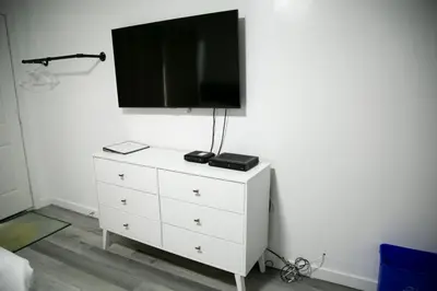 a white dresser with a tv on top of it at Westview Centre Motel Ltd in Powell River