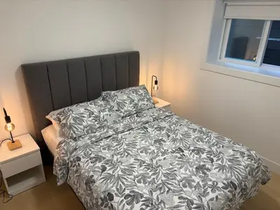 a bedroom with a bed with a black and white comforter at Cozy Private Suite in Langley in Langley