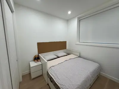 a small bedroom with a bed and a window at New Lux House on Vancouver West in Vancouver