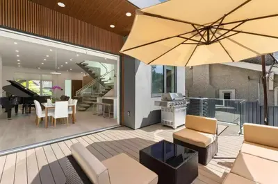a living room with a patio with a large umbrella at New Lux House on Vancouver West in Vancouver