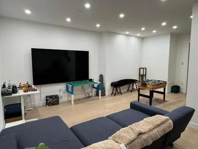 a living room with a couch and a flat screen tv at New Lux House on Vancouver West in Vancouver