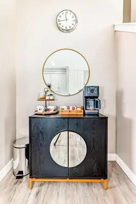 a mirror on a wall above a black cabinet with a microwave at Cozyhub Vacation Rental Calgary-3Bedroom with AC in Calgary