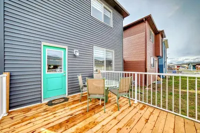 a patio with a table and chairs on a deck at Cozyhub Vacation Rental Calgary-3Bedroom with AC in Calgary