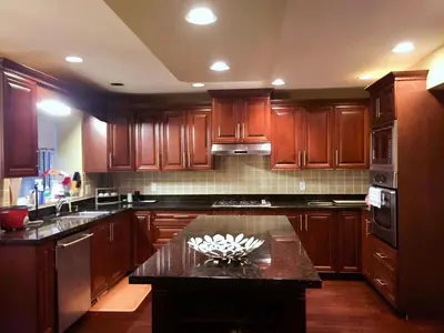 a kitchen with wooden cabinets and a counter top at Sandy's Sweet Home in Coquitlam