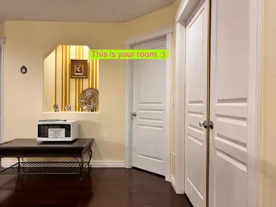a room with a door and a table with a microwave at Sandy's Sweet Home in Coquitlam