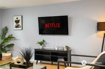 a living room with a television on a wall at Spacious Cozy Couples Getaway Basement Suite in Sundance in Calgary