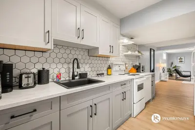 a kitchen with white cabinets and a sink at Spacious Cozy Couples Getaway Basement Suite in Sundance in Calgary