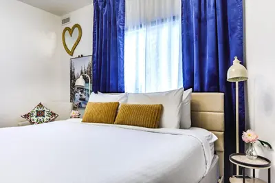 a bedroom with a large bed with blue curtains at Westwinds - Funky Basecamp in the Rockies in Canmore