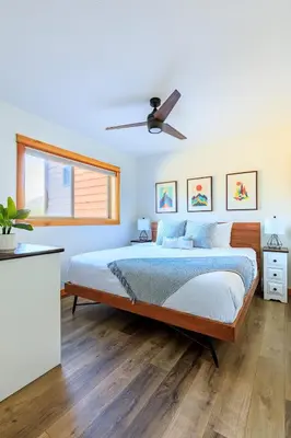 a bedroom with a bed and a ceiling fan at Bluebird - Spacious Luxury Shared Rooftop Hot Tub in Canmore