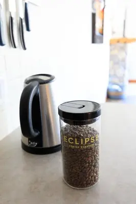 a jar of coffee beans next to a coffee pot at Bluebird - Spacious Luxury Shared Rooftop Hot Tub in Canmore