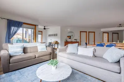 a living room with two couches and a table at Bluebird - Spacious Luxury Shared Rooftop Hot Tub in Canmore