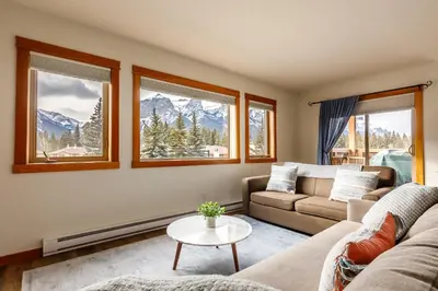 a living room with a couch and a table at Bluebird - Spacious Luxury Shared Rooftop Hot Tub in Canmore