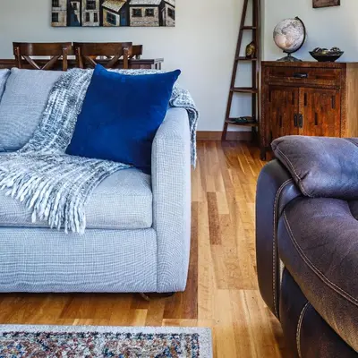 a blue couch in a living room with a wooden floor at McAuley Manor - Mountain Views Downtown Location in Canmore