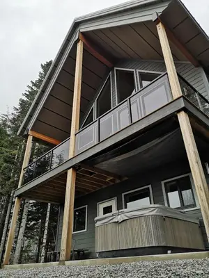 a house with a wrap around porch with a balcony at Après-Ski Lodge in Agassiz