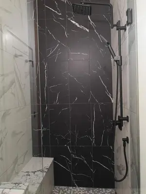 a bathroom with a shower with a black marble wall at Après-Ski Lodge in Agassiz
