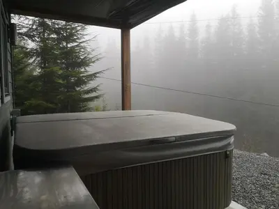 a hot tub sitting on the side of a house at Après-Ski Lodge in Agassiz