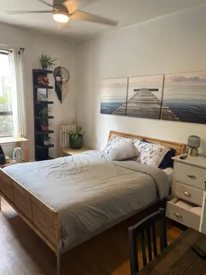 a bedroom with a bed and a painting on the wall at Ophelias Casa in Vancouver