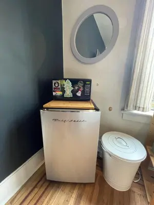 a small bathroom with a toilet and a mirror at Ophelias Casa in Vancouver