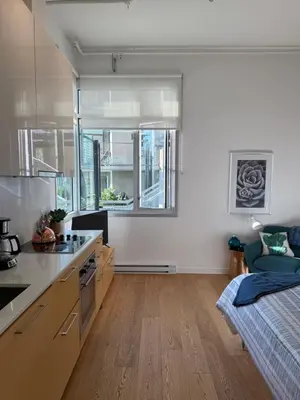 a kitchen with white walls and a bed in a room at Downtown Studio Rental in Victoria