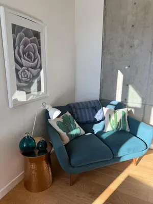 a blue couch in a living room with a lamp at Downtown Studio Rental in Victoria
