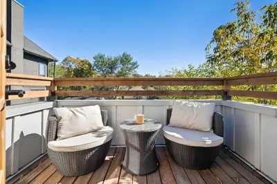 two chairs and a table on a deck at The Sunny 2 Suites 10 Pax Pet Friendly Stay in Calgary