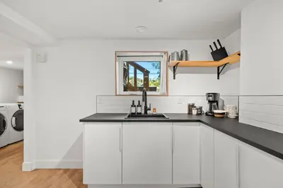 a white kitchen with a sink and a microwave at The Sunny 2 Suites 10 Pax Pet Friendly Stay in Calgary