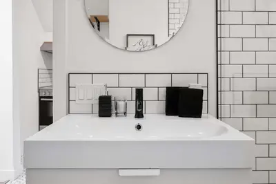 a white bathroom with a sink and a mirror at The Lokal 2 Kings Queen Suite in Sunnyside YYC in Calgary