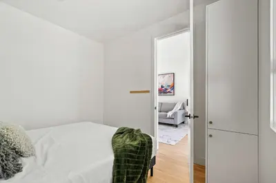 a white bedroom with a bed and a mirror at The Lokal 2 Kings Queen Suite in Sunnyside YYC in Calgary