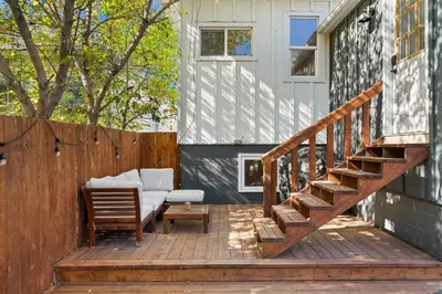 a deck with a couch and a chair on a house at The Lokal 2 Kings Queen Suite in Sunnyside YYC in Calgary