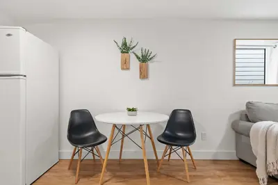 a living room with a table and three black chairs at The Sunday Charming Private Suite in Calgary in Calgary