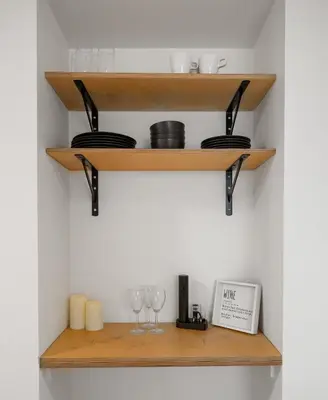 a shelf with glasses and wine glasses at The Sunday Charming Private Suite in Calgary in Calgary