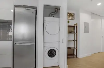 a white washer and dryer in a room at Urban Calm, Comfort in the Heart of the City in Vancouver
