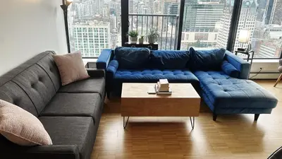 a living room with a blue couch and a table at Urban Calm, Comfort in the Heart of the City in Vancouver