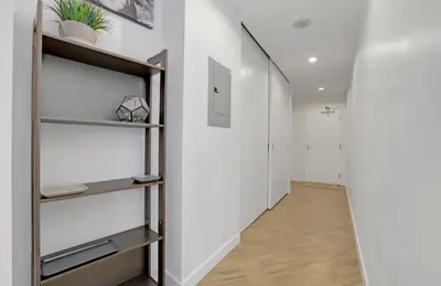 a hallway with white walls and wooden floors and shelves at Urban Calm, Comfort in the Heart of the City in Vancouver