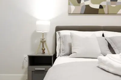 a bedroom with a bed with a lamp on a nightstand at Cozy 2BR for Family & Private Parking & Near Mall in Langley