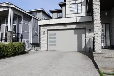 a white garage door in front of a house at Cozy 2BR for Family & Private Parking & Near Mall in Langley