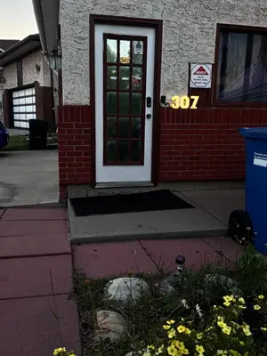 a front door of a house with a sign that reads at Only 7 km from YYC Sandstone Homestay in Calgary