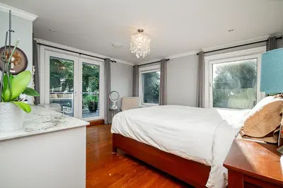 a bedroom with a large bed and windows at World Cup Coastal Getaway in White Rock