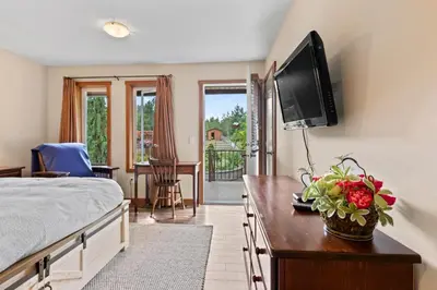 a bedroom with a bed and a television on a wall at Ackerview Guesthouse Bed and Breakfast in Salmon Arm