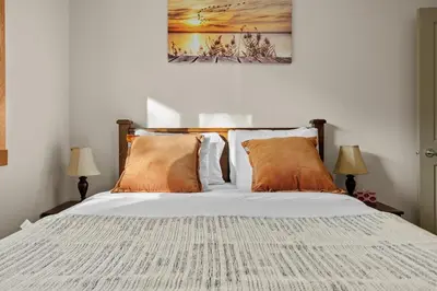 a bedroom with a large bed with orange pillows at Lodges at Canmore Resort in Canmore