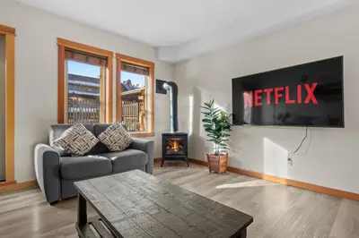 a living room with a couch and a tv at Lodges at Canmore Resort in Canmore